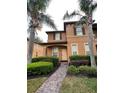 Charming two-story townhouse featuring manicured landscaping and a welcoming front entrance with a brick walkway at 130 Napoli Dr, Davenport, FL 33897