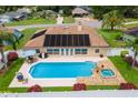 Backyard with a pool and hot tub, solar panels, patio furniture, and white fencing at 1414 Cove Pl, Tavares, FL 32778