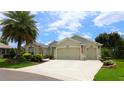Beautiful home with a three-car garage and landscaped front yard under a sunny sky at 1553 Lynchburg Loop, The Villages, FL 32162