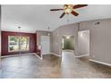 Spacious living room with tile flooring, neutral walls, decorative lighting, and multiple entryways at 15916 Indian Wells Ct, Clermont, FL 34711