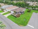 Aerial view of a cozy single-story home with a screened lanai, garage, and lush green lawn in a quiet neighborhood at 17461 Se 82Nd Albemarle Ave, The Villages, FL 32162