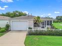 Well-maintained single-story home with attached garage, manicured lawn, and a welcoming screened porch at 17461 Se 82Nd Albemarle Ave, The Villages, FL 32162