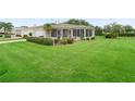 Beautifully landscaped front yard with lush green grass, mature plantings, and a charming single-story home at 17461 Se 82Nd Albemarle Ave, The Villages, FL 32162