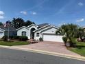 Beautiful single-story home boasting a brick driveway and landscaped yard with a palm tree at 20936 Royal St Georges Ln, Leesburg, FL 34748