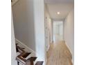 Hallway with wood-look floors leads to bedrooms and living spaces, with stairs to the left at 2153 Axel St, Minneola, FL 34715