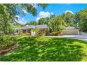Spacious house with well-manicured lawn, colorful flower beds, and a detached garage at 2214 Dogwood Cir, Mount Dora, FL 32757