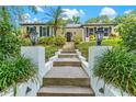 View up walkway to the front door, flanked by elegant lanterns and vibrant landscaping at 2214 Dogwood Cir, Mount Dora, FL 32757