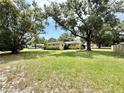 Expansive front yard showcasing the home's position on a large, grassy lot with mature trees at 2237 Washington Rd, Mount Dora, FL 32757