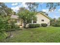 A view of the backyard with lush green lawn and shrubbery around the perimeter of the house at 24 Brigadoon Cir, Leesburg, FL 34788