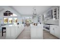Spacious kitchen featuring an island, stainless steel appliances, white cabinetry, and a view of the living room at 2421 Shady Ln, Groveland, FL 34736