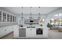 Gourmet kitchen with stainless steel appliances, custom cabinetry, granite countertops, and modern lighting at 2421 Shady Ln, Groveland, FL 34736