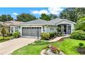 Charming home with lush landscaping, a two-car garage, and inviting walkway at 27302 Stoney Brook Dr, Leesburg, FL 34748