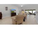 Bright and airy living room featuring a tile floor, a ceiling fan, and sliding glass doors to the lanai at 2954 Heiny Pl, The Villages, FL 32163