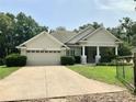 Inviting single-story home featuring a spacious two-car garage and covered porch area at 30604 Apawamis Dr, Sorrento, FL 32776