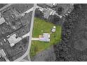 An aerial view of a home with a large green lawn, located near trees and other neighborhood properties at 316 Dupont Cir, Howey In The Hills, FL 34737
