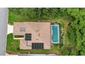 An aerial view of the house showing roof solar panels and screened in backyard pool at 32948 Rambling Oaks Ct, Leesburg, FL 34748