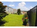 A spacious fenced backyard featuring lush greenery, potted plants, and a well-maintained lawn at 33647 Sky Blossom Cir, Leesburg, FL 34788