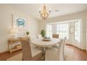 Sunlit dining room featuring a chandelier, crab artwork, and bay window at 37236 Cherry Lake Rd, Fruitland Park, FL 34731