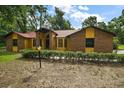 A inviting single-story home with a well-manicured front yard and classic brick and siding design at 37236 Cherry Lake Rd, Fruitland Park, FL 34731