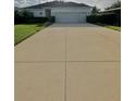 Charming single-story home featuring a well-manicured lawn and a long driveway leading to a two-car garage at 3819 Saint Emma Ct, Leesburg, FL 34748