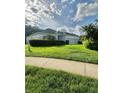 Charming single-story home featuring a well-manicured lawn and a long driveway leading to a two-car garage at 3819 Saint Emma Ct, Leesburg, FL 34748