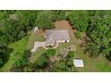 Expansive aerial view of a single-Gathering home with a large yard, surrounded by mature trees and manicured landscaping at 39132 Grays Airport Rd, Lady Lake, FL 32159
