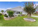 Beautifully landscaped front yard with mature trees, flower beds, and a well-maintained lawn at 3978 Nottingham Loop, The Villages, FL 32163