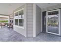 Inviting front porch with decorative stone flooring, comfortable seating, and charming front door at 3978 Nottingham Loop, The Villages, FL 32163