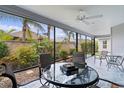 Screened patio with ceiling fan, outdoor furniture, and view of a lush backyard with landscaping at 3978 Nottingham Loop, The Villages, FL 32163