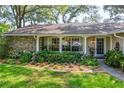 Close-up of a home's front yard showcasing lush landscaping and charming stone accents at 500 Lake Forest Cir, Mount Dora, FL 32757