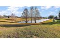 Scenic view of a tranquil pond surrounded by lush greenery and mature trees in a neighborhood at 5046 Harbour Dr, Oxford, FL 34484