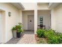 Inviting front entrance with a brick pathway, cozy bench, and potted plants at 5090 Greens Dr, Lady Lake, FL 32159