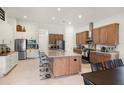 Bright, modern kitchen with two-tone cabinets, stainless steel appliances, and a large center island with bar seating at 5090 Greens Dr, Lady Lake, FL 32159