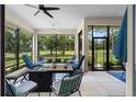 Screened patio with comfortable seating arrangements, perfect for relaxation and overlooking a lush green landscape at 5090 Greens Dr, Lady Lake, FL 32159