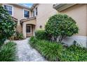 Inviting front entrance with well-manicured landscaping and a stone pathway leading to the front door at 52 Camino Real Blvd, Howey In The Hills, FL 34737