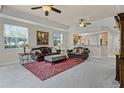 Cozy living room features plush seating, ceiling fans, and view into kitchen at 52 Camino Real Blvd, Howey In The Hills, FL 34737