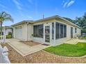 Exterior view of home featuring attached garage and enclosed lanai with patio furniture at 8195 Se 174Th Rowland St, The Villages, FL 32162