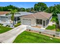 Aerial view of a well-maintained home with a garage, screen porch, and landscaped yard at 8195 Se 174Th Rowland St, The Villages, FL 32162