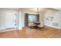 Bright dining area with wood floors, column, large window with curtains, and elegant chandelier at 832 Willow Run St, Minneola, FL 34715