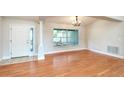 Bright dining area with wood floors, column, large window, and chandelier at 832 Willow Run St, Minneola, FL 34715