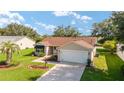 Well-maintained home featuring lush landscaping, a two-car garage, and neutral siding at 8537 Se 177Th Bartram Loop, The Villages, FL 32162