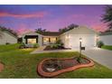 Inviting home with manicured lawn, landscape lighting, and a charming front porch at 8537 Se 177Th Bartram Loop, The Villages, FL 32162