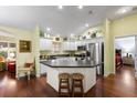 Bright kitchen features stainless steel appliances, an island with seating, and hardwood floors at 891 Lucky Ln, The Villages, FL 32162