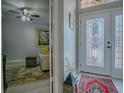 Welcoming foyer featuring a decorative glass front door, stylish rug, and a glimpse into the living room at 903 Santa Anna Ln, Lady Lake, FL 32159