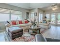 Bright living room with large windows, comfortable seating, wooden floors, and a stylish area rug at 903 Santa Anna Ln, Lady Lake, FL 32159