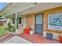 Inviting front porch with unique wood details, colorful planters, and cozy bench seating at 1 W Pierce Ave, Orlando, FL 32809