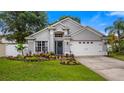Beautiful single-Gathering home with a lush front yard, a two-car garage, and a welcoming entrance at 1130 Woodsong Way, Clermont, FL 34714