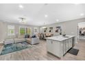 Open-concept living space with modern furnishings, wood-look tile, a center island, and large windows at 15954 Winding Bluff Dr, Montverde, FL 34756