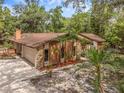 An elevated side view of the house showing a stone facade, mature landscaping, large driveway, and attached two-car garage at 161 Cindy Ct, Lake Mary, FL 32746