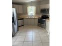 Modern kitchen with stainless steel appliances, light countertops, and ample cabinet space at 1626 Cypress Pt, Lady Lake, FL 32159